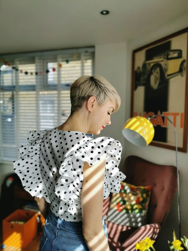 Back view of the Bella Loves Flor top in black and white polka dot cotton.